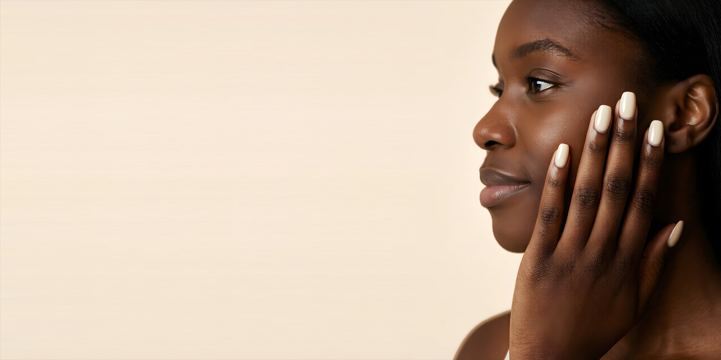 Woman with freshly cured cream gel nails resting her hand against her face